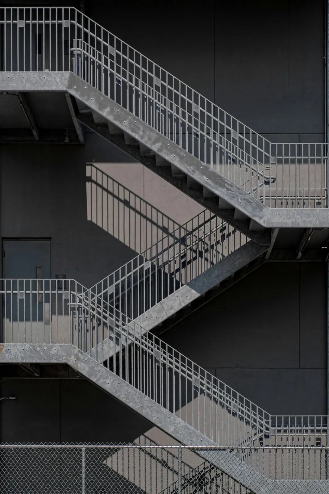 Betonowa klatka schodowa z metalowymi balustradami w budynku